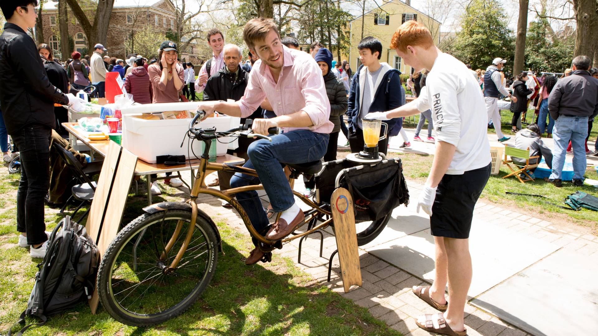 Student pedaling bicycle to power up a blender