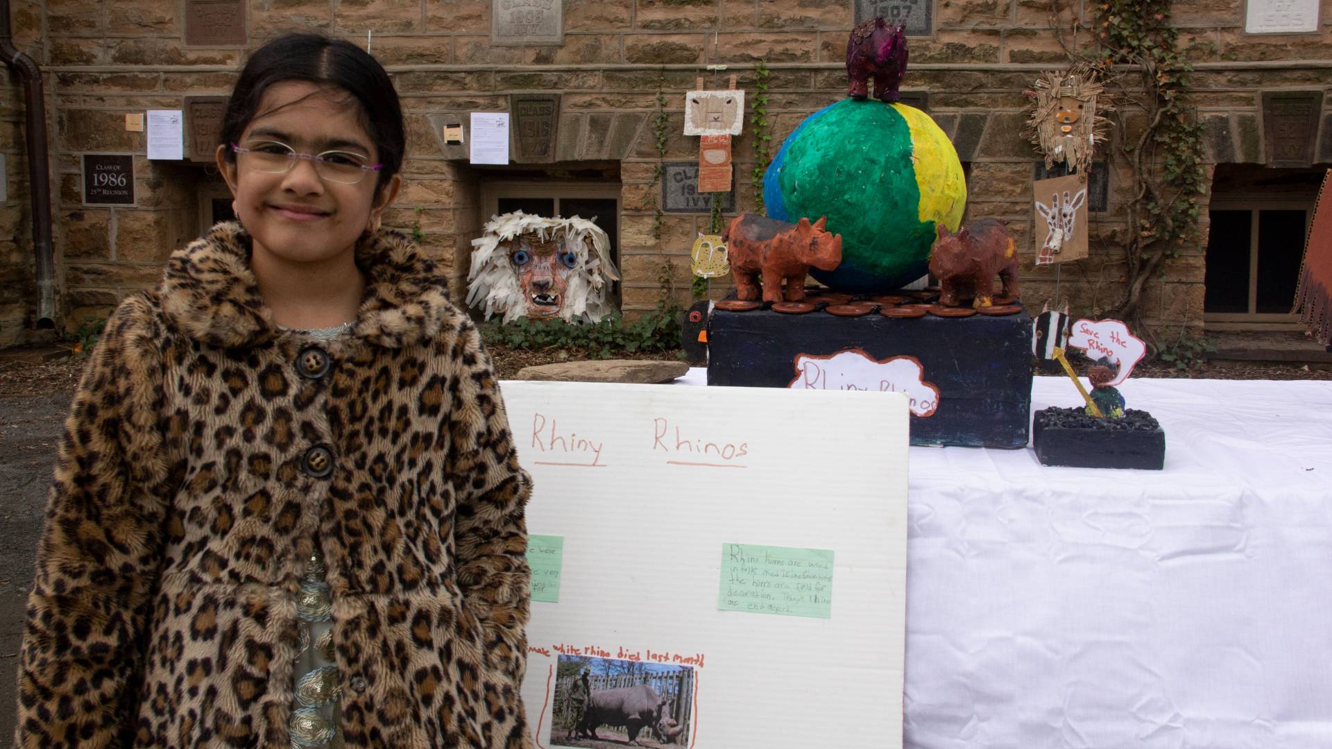 Ryka Iyer standing in front of her "Rhiny" Rhinos trash art piece