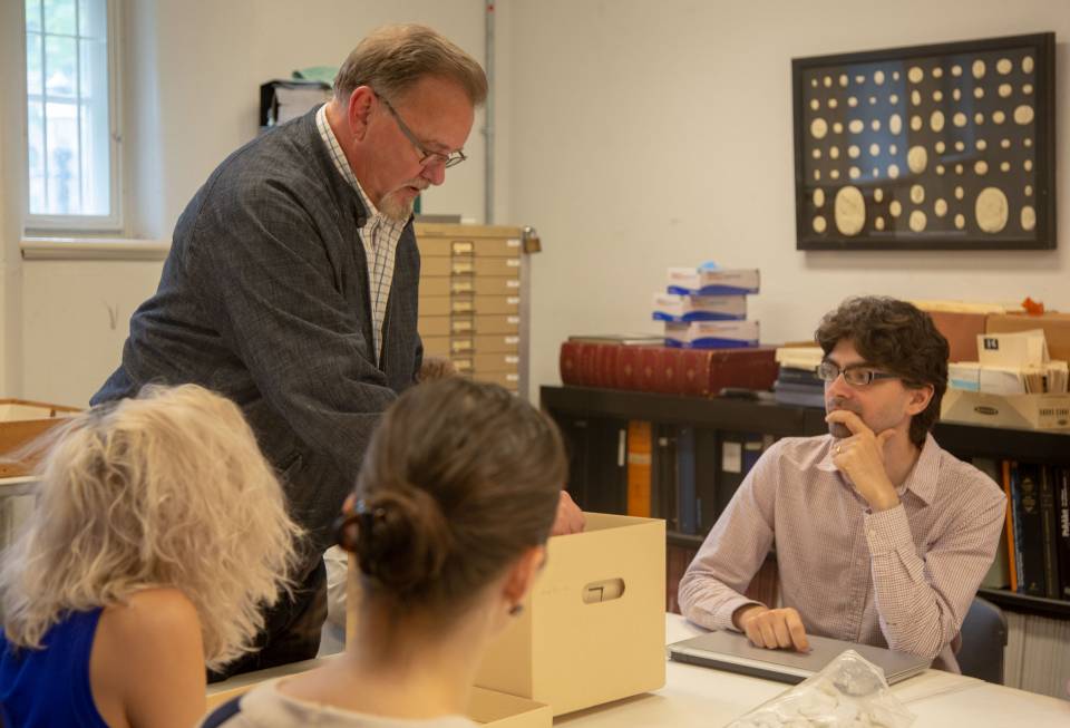 Michael Pagett with graduate students looking at documents from Art Museum