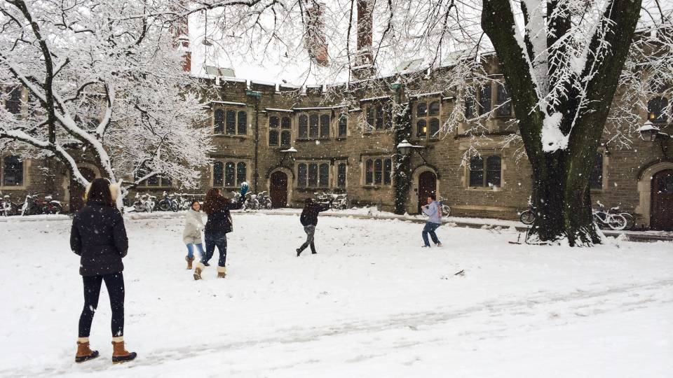 students play in the snow on campus