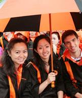 Seniors gather under a Tiger umbrella