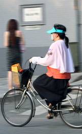 woman in mask on bicycle