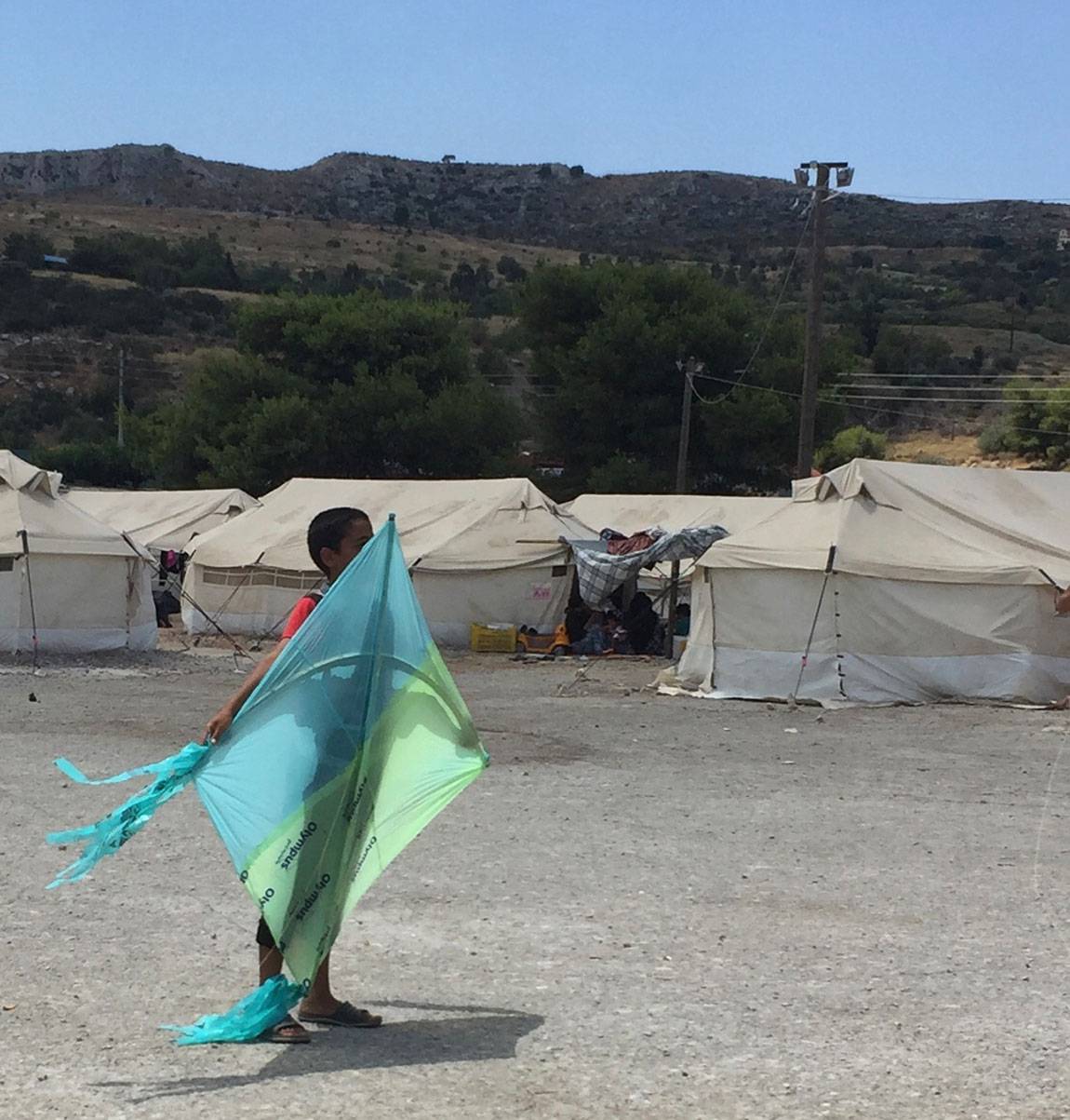 A Tale of Two Countries: Greece - boy with kite at Schisto camp