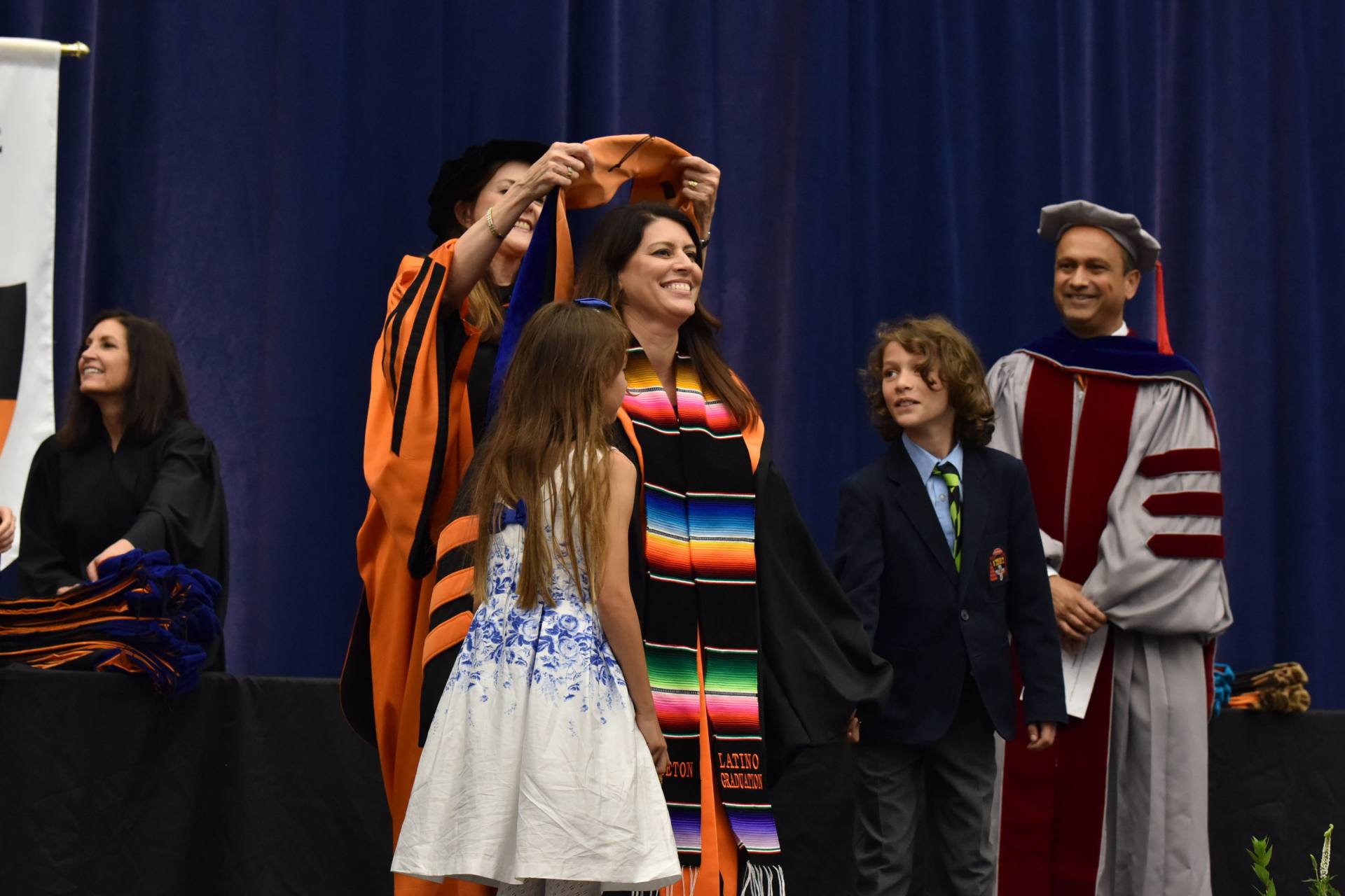 Student stands with son and daughter during hooding