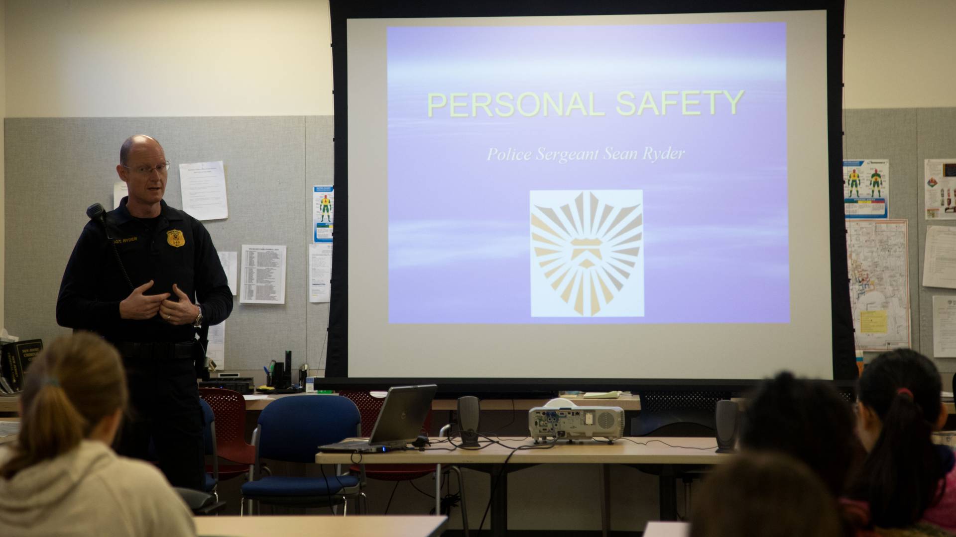 Public Safety officer Sean Ryder teaching safety course; Text on Slide: Personal Safety; Police Sergeant Sean Ryder