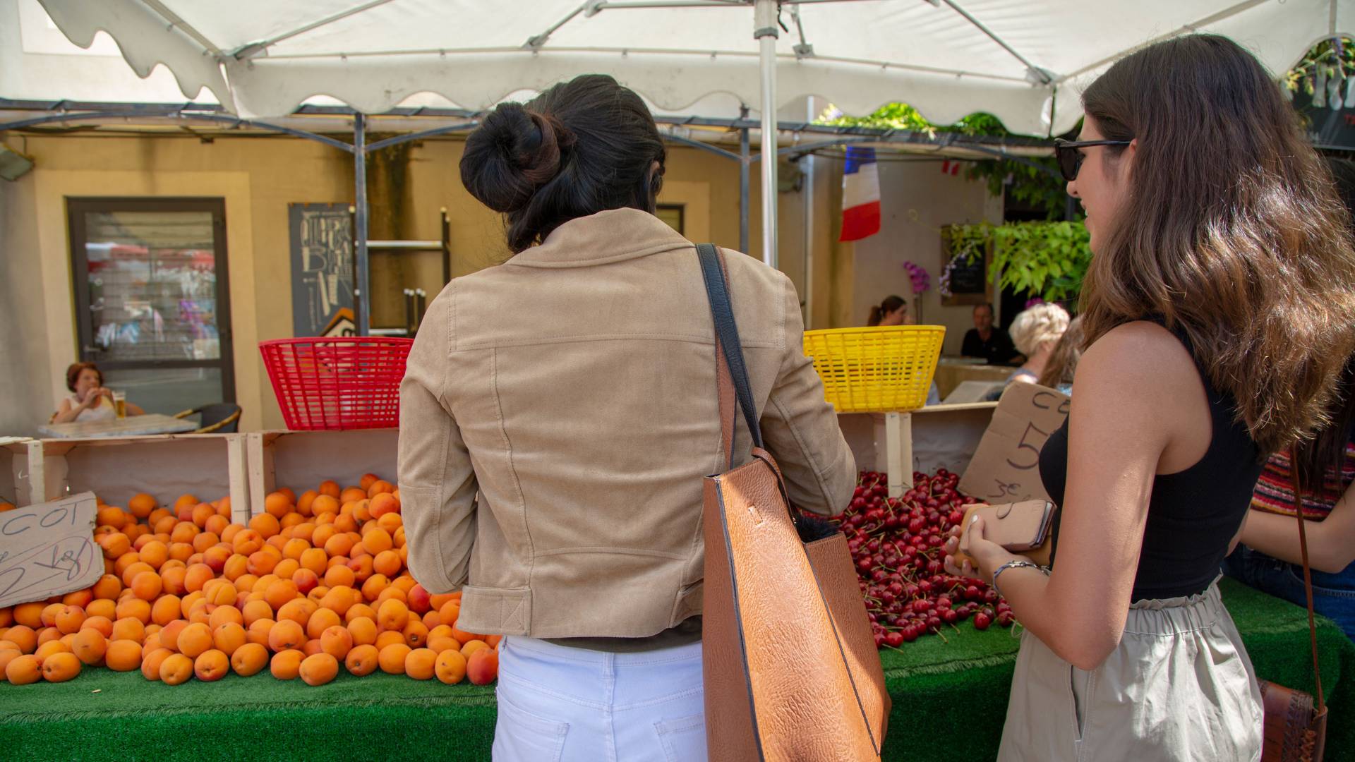 Students looking at fruit in outdoor market in France