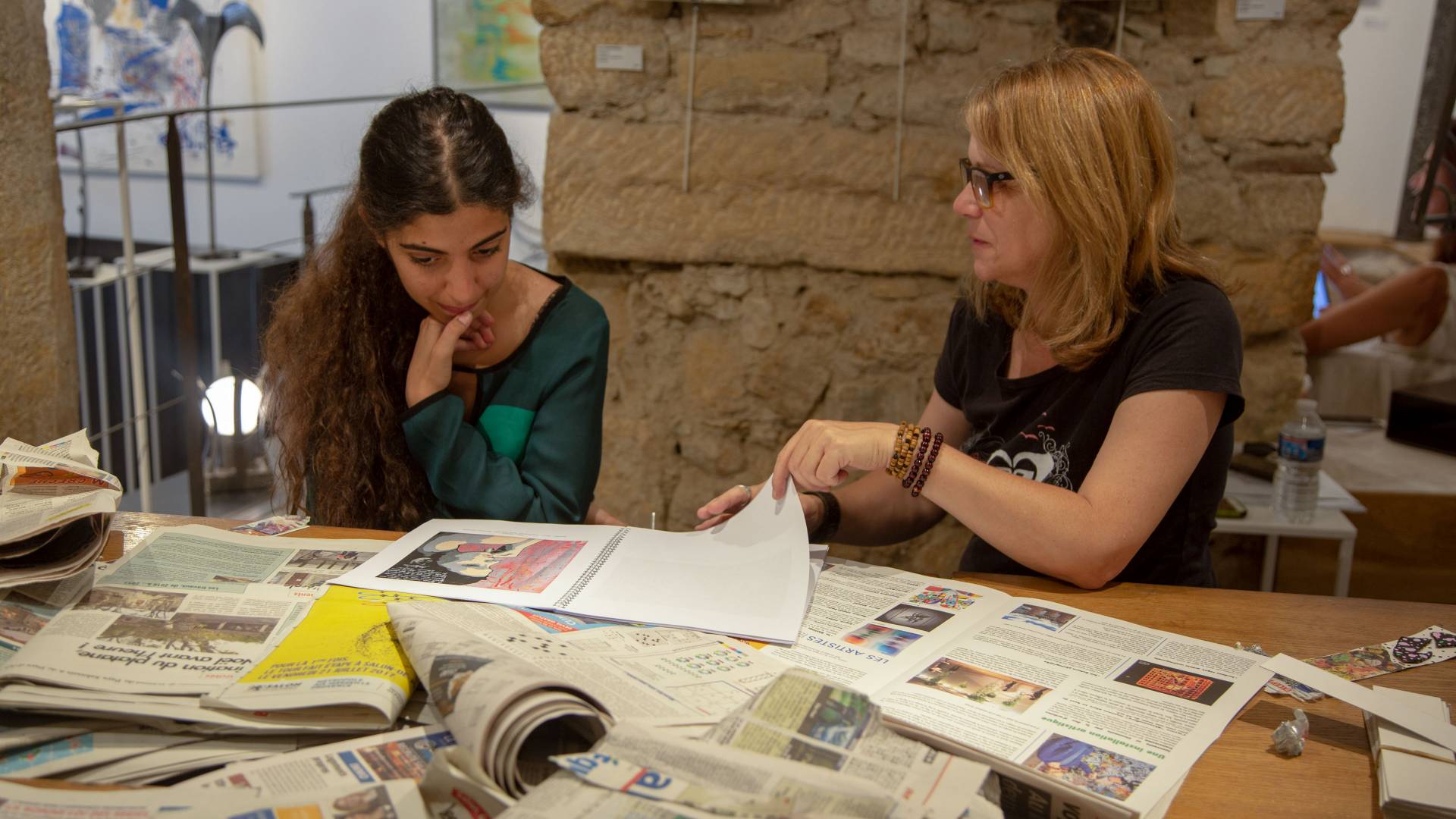Instructor and student looking at newspapers in France