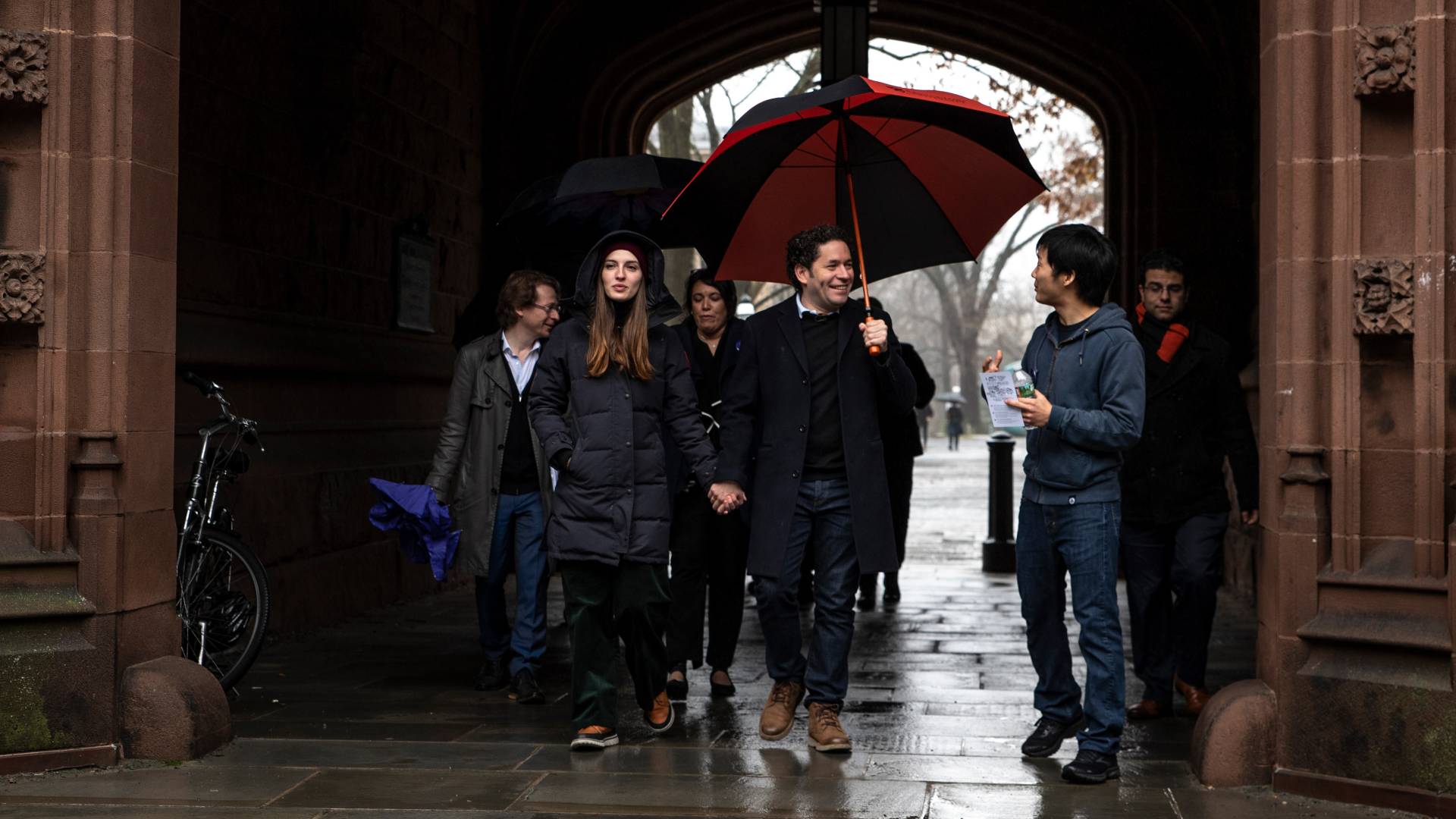 Gustavo Dudamel and people walking through Princeton archway