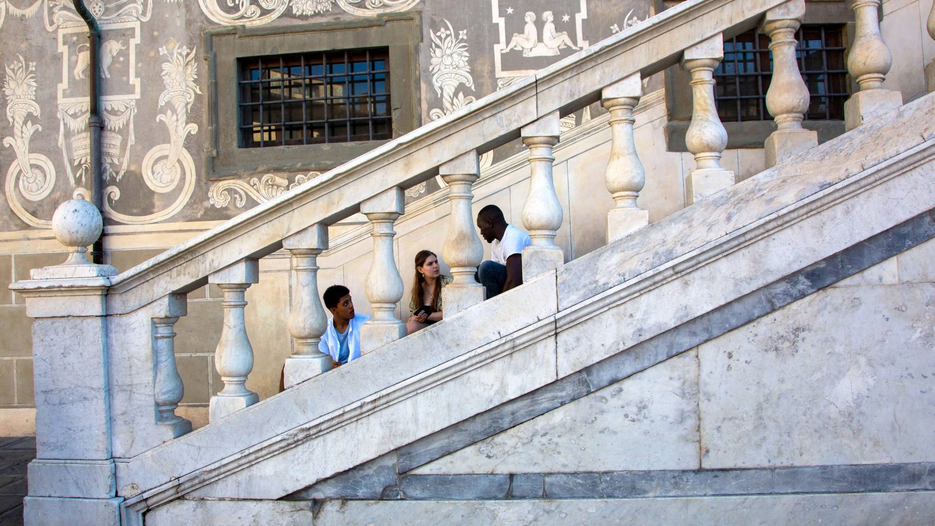 Three students sitting on steps