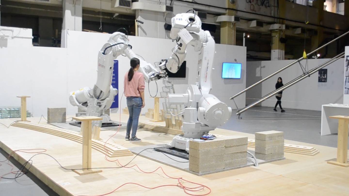 a students watches the two robots work