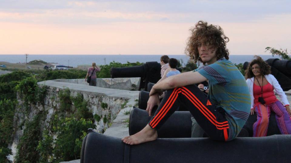 Kyle Berlin sitting on cannon in Cuba