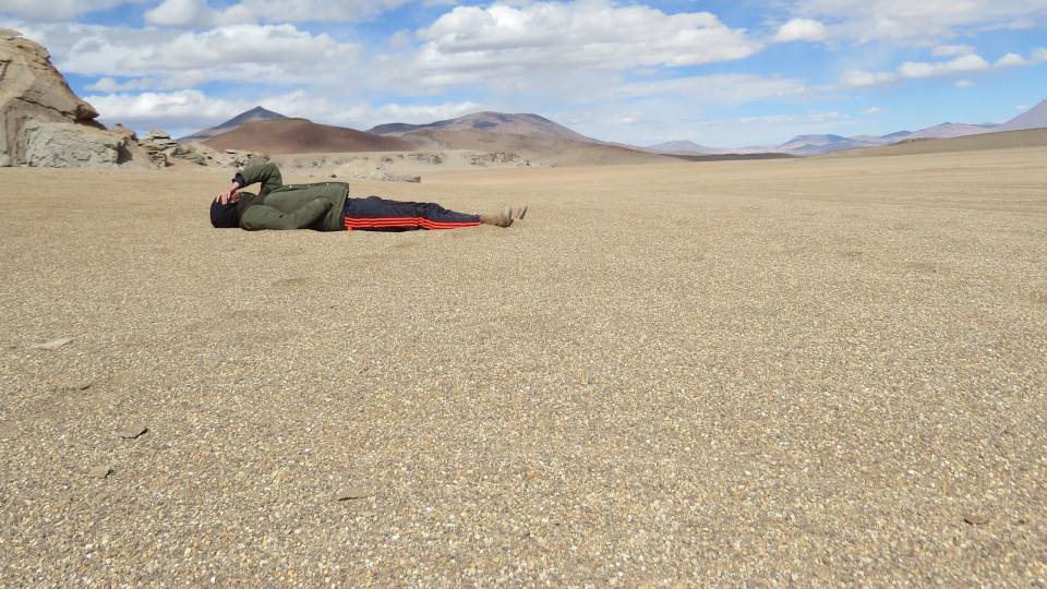 Kyle Berlin lying in dirt field in Uyuni, Bolivia