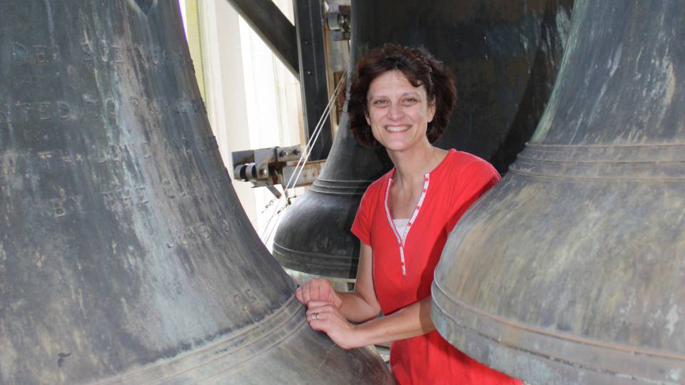 Lisa Lonie amid the carillon bells atop Cleveland Tower at the Graduate College.