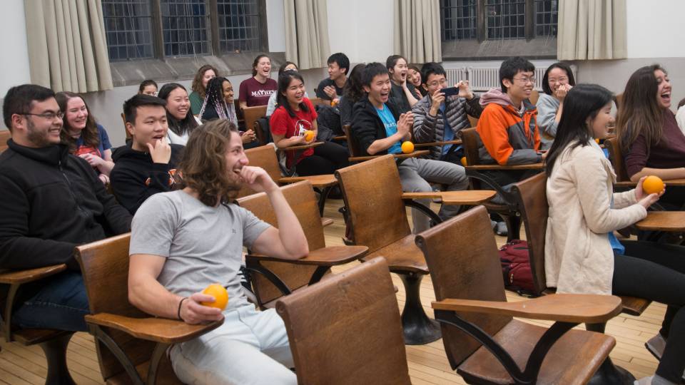 Students laughing in class on how to peel an orange