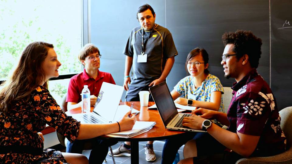 Students and researchers gather around a table