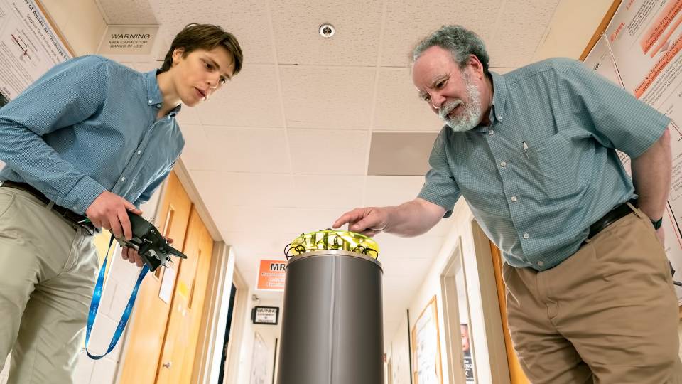 2 scientists examine a machine