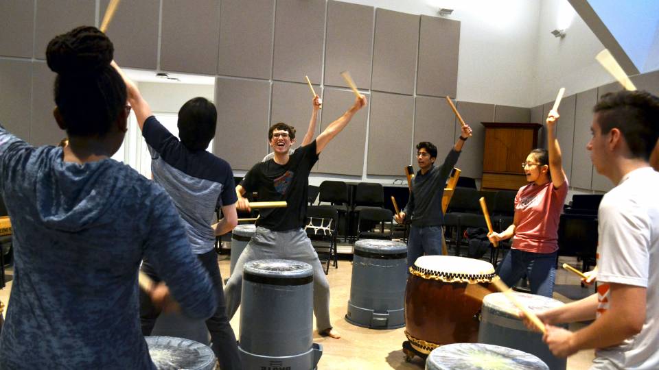Students drumming enthusiastically