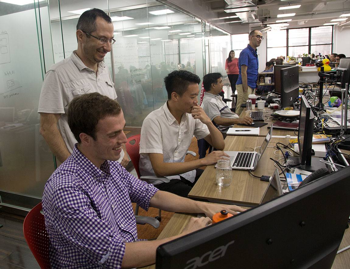Princeton Start-Up Immersion Program juniors Raoul Rodriguez and Daniel Liu (seated left to right in foreground) work with Boris Boroda (standing), vice president of engineering at AbilTo
