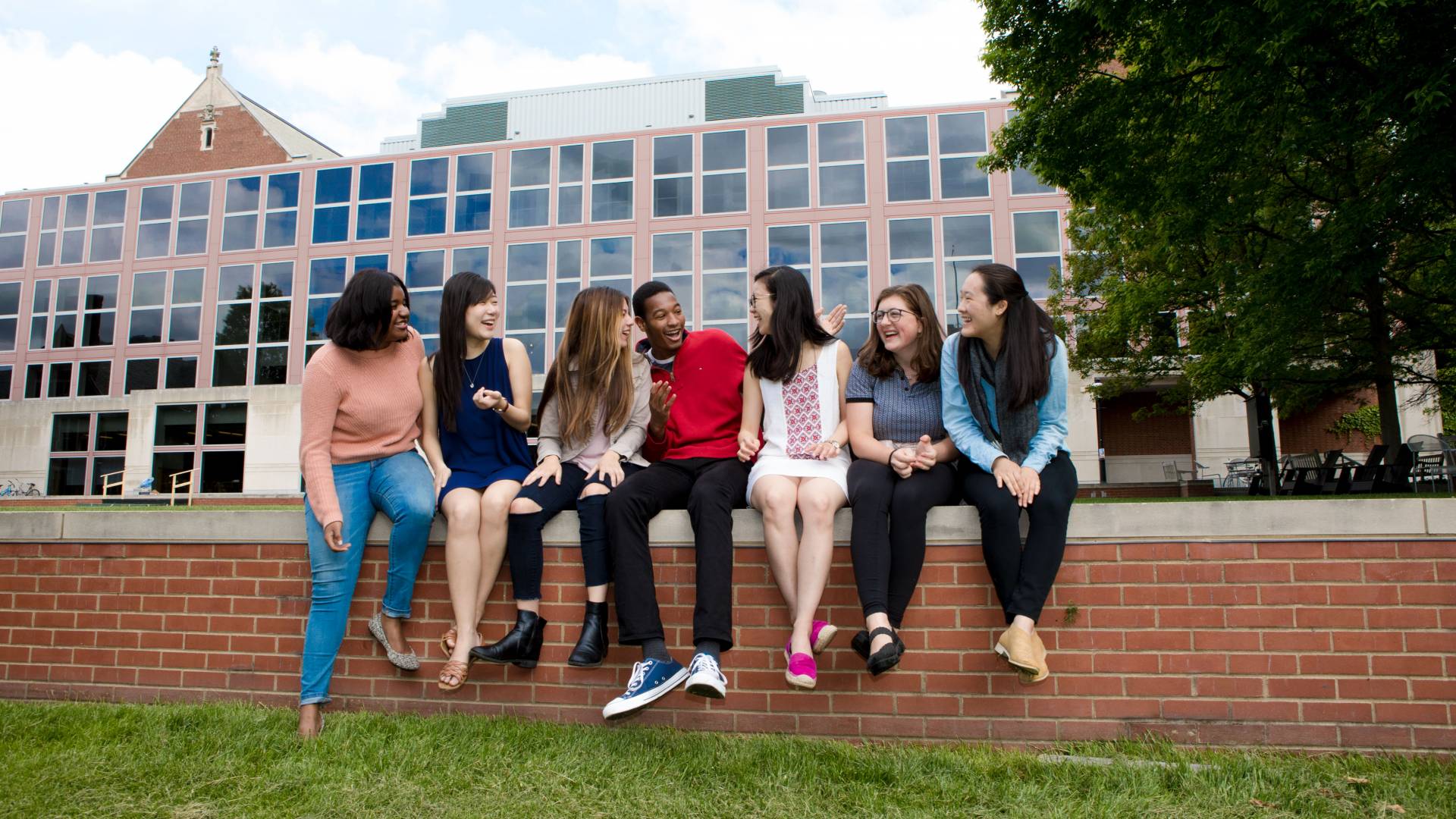Jin Yun Chow and friends sitting on wall behind Frist Campus Center