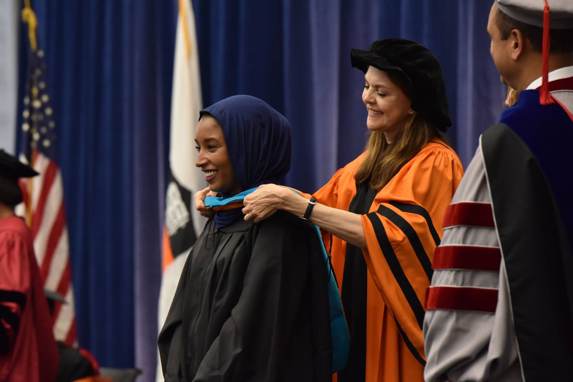Student receives hood from Professor Bermann