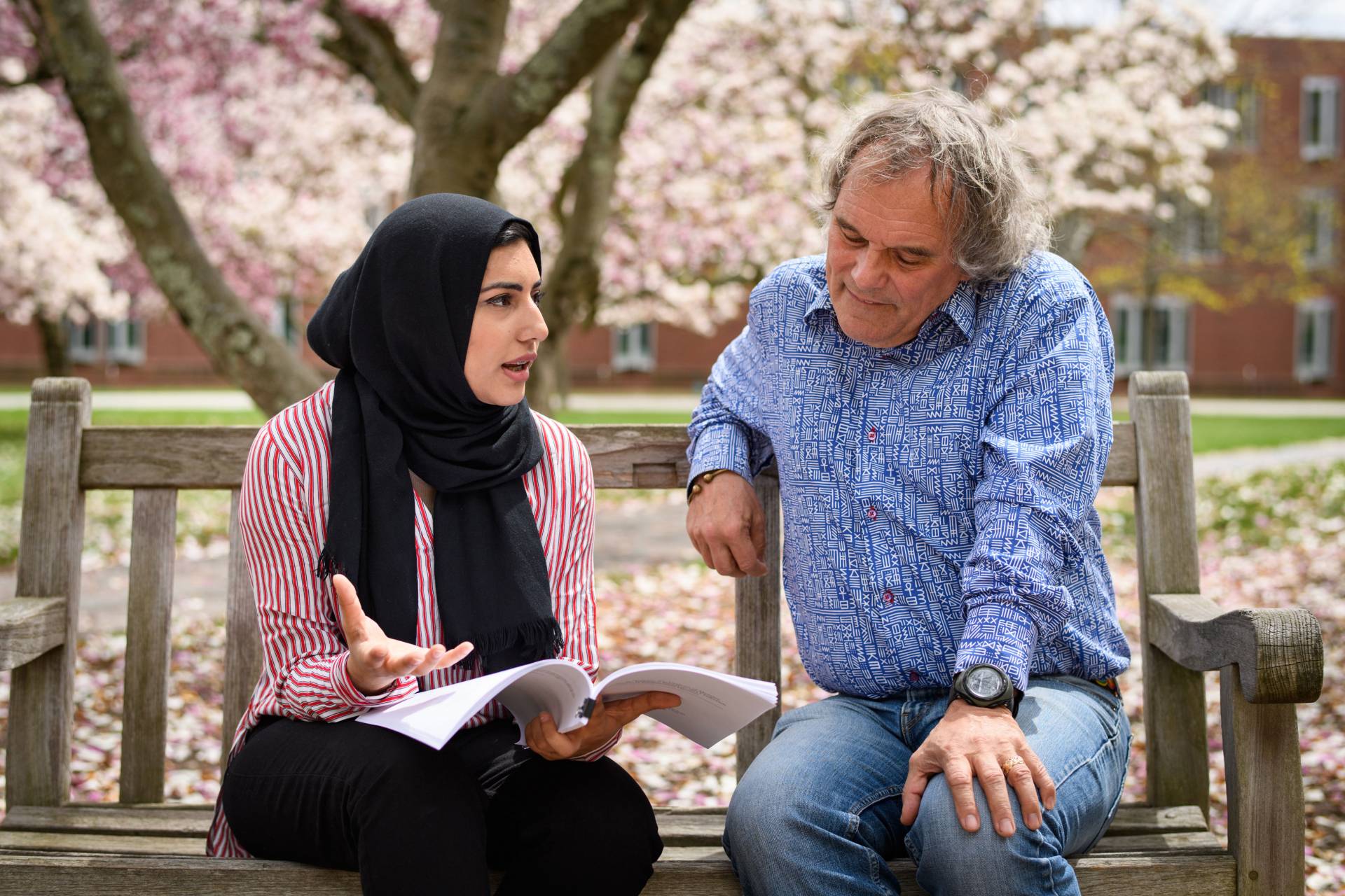 Raia Khan and professor Andrew Dobson sitting outside on bench