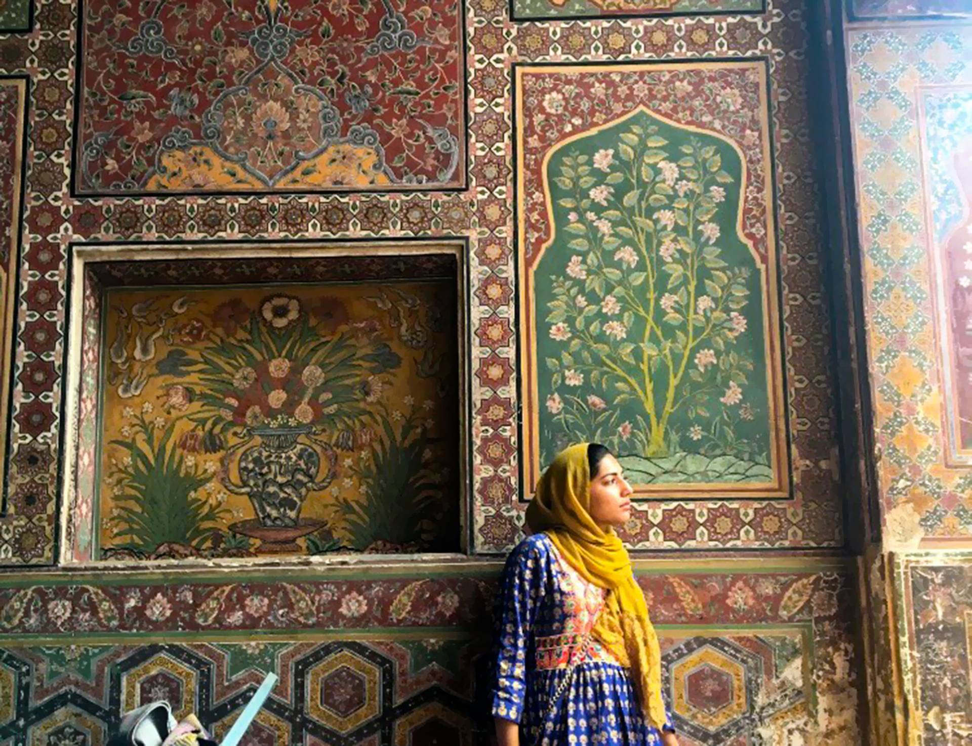 Rabia Khan standing in front of tiled mosque wall