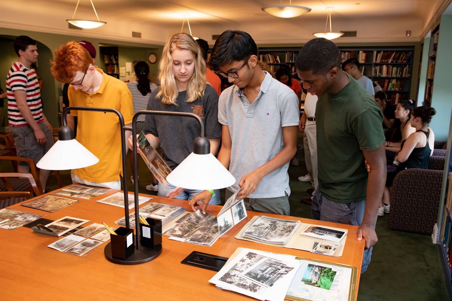 Students looking at old papers, pamphlets and photos of Princeton