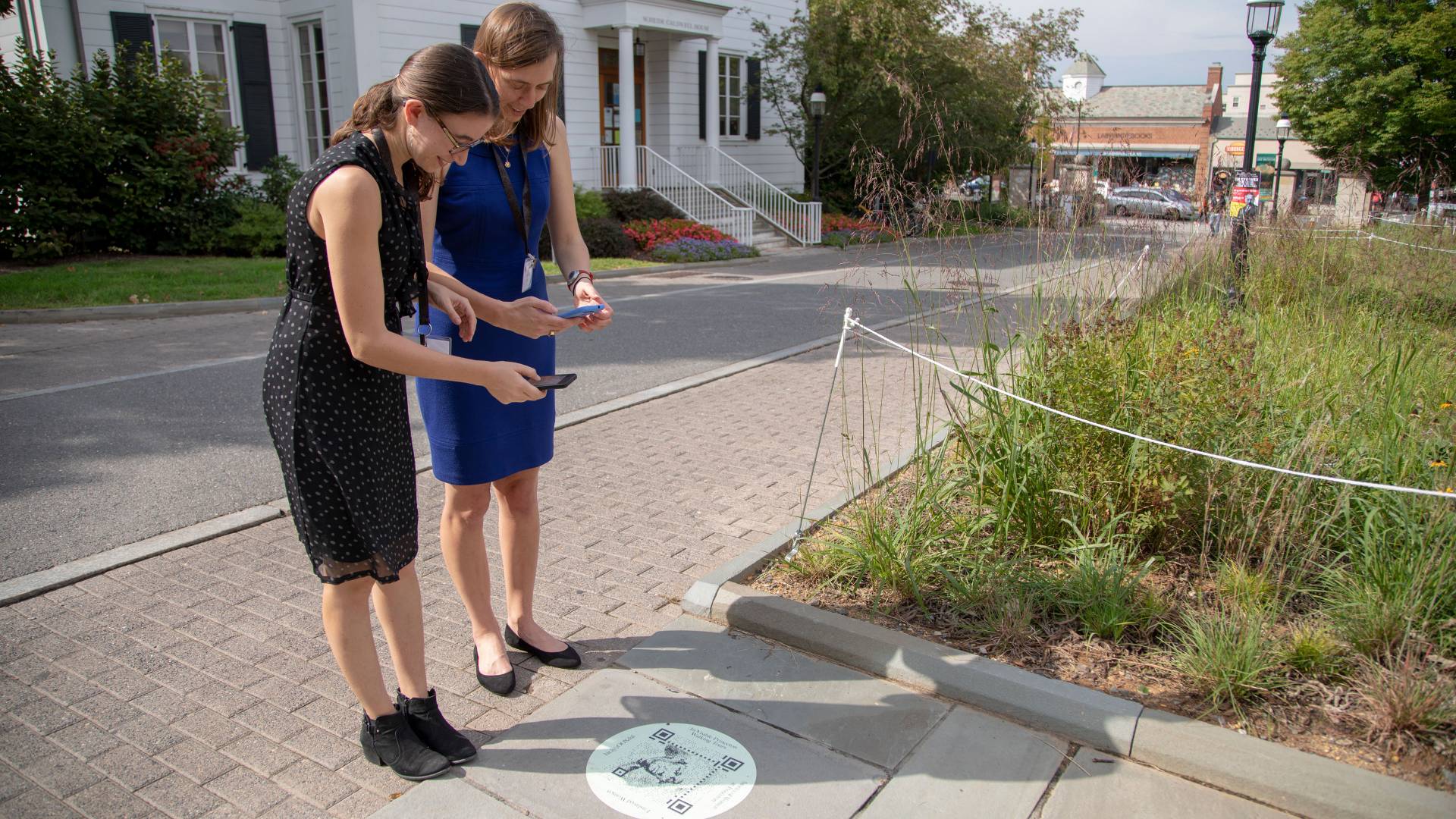 Abby Klionsky ’14 showing Caroline Stone ’14 how to scan the QR code at the Betsey Stockton Garden outside Firestone Library