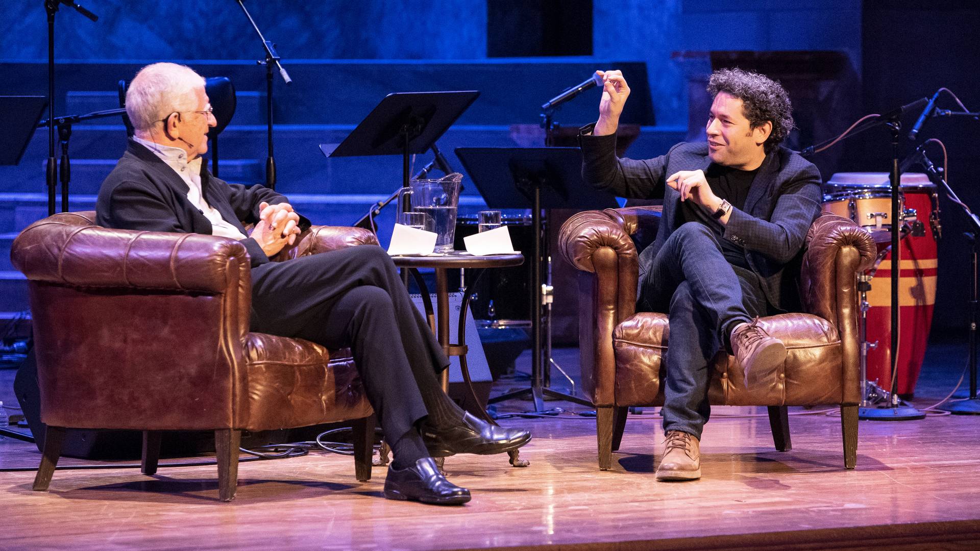 Don Michael Randal sitting on stage with Gustavo Dudamel