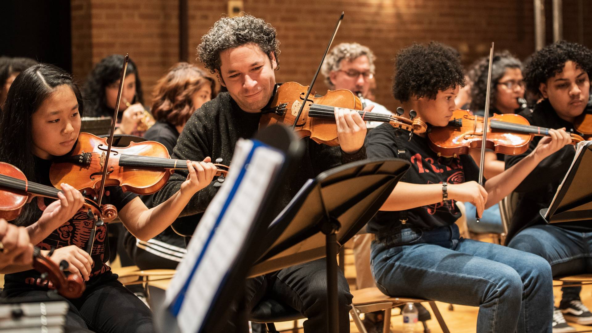 Gustavo Dudamel playing violin with student orchestra