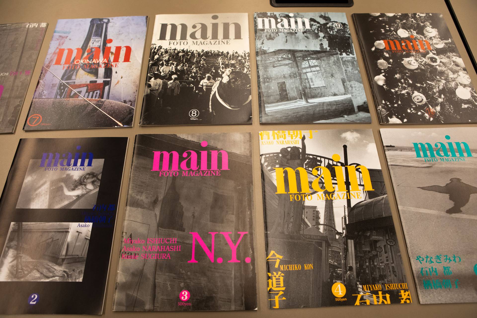 Issues of "Main" laid out on a table in a grid