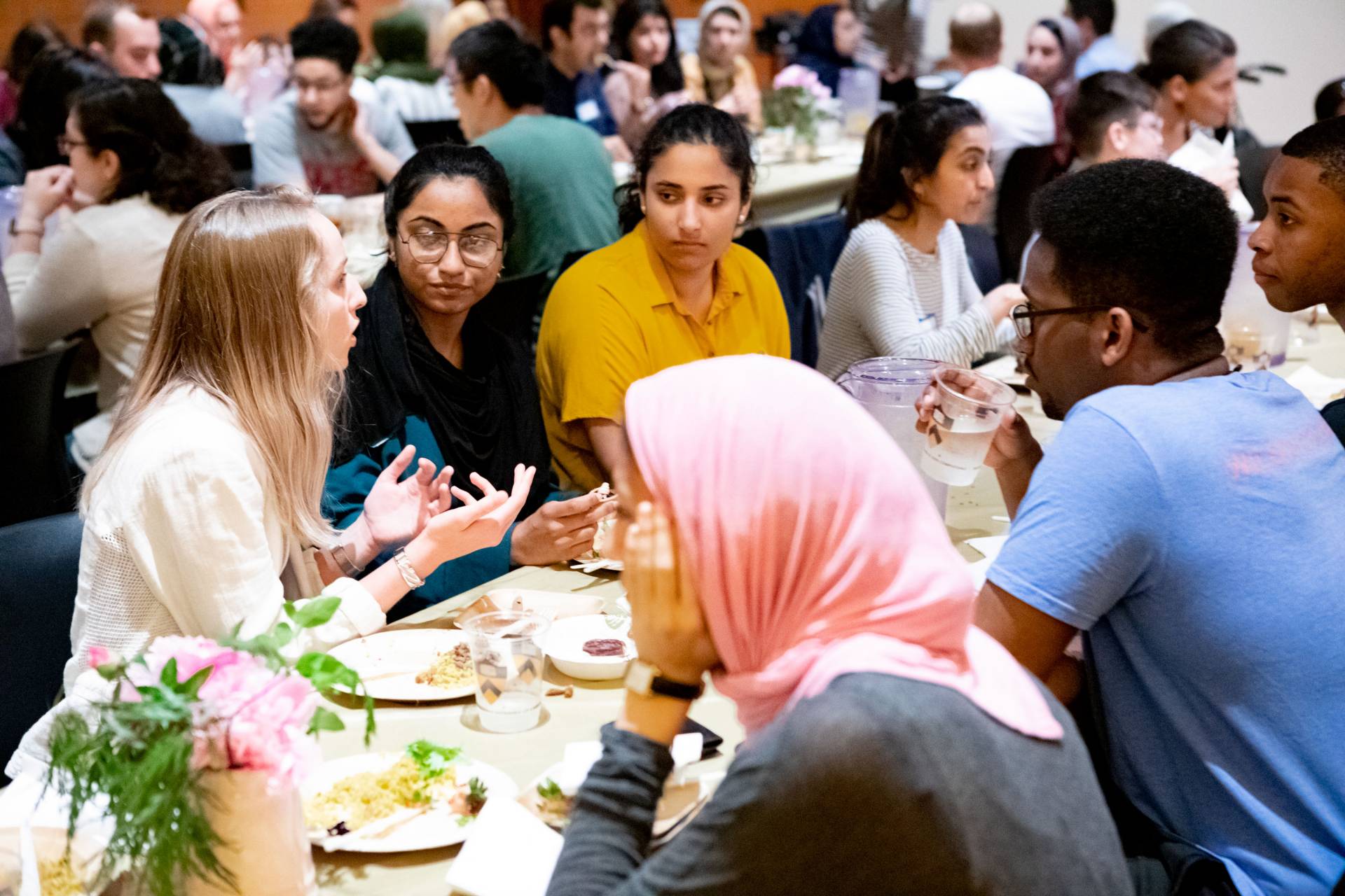 Students eating and speaking with one another at the interfaith dinner