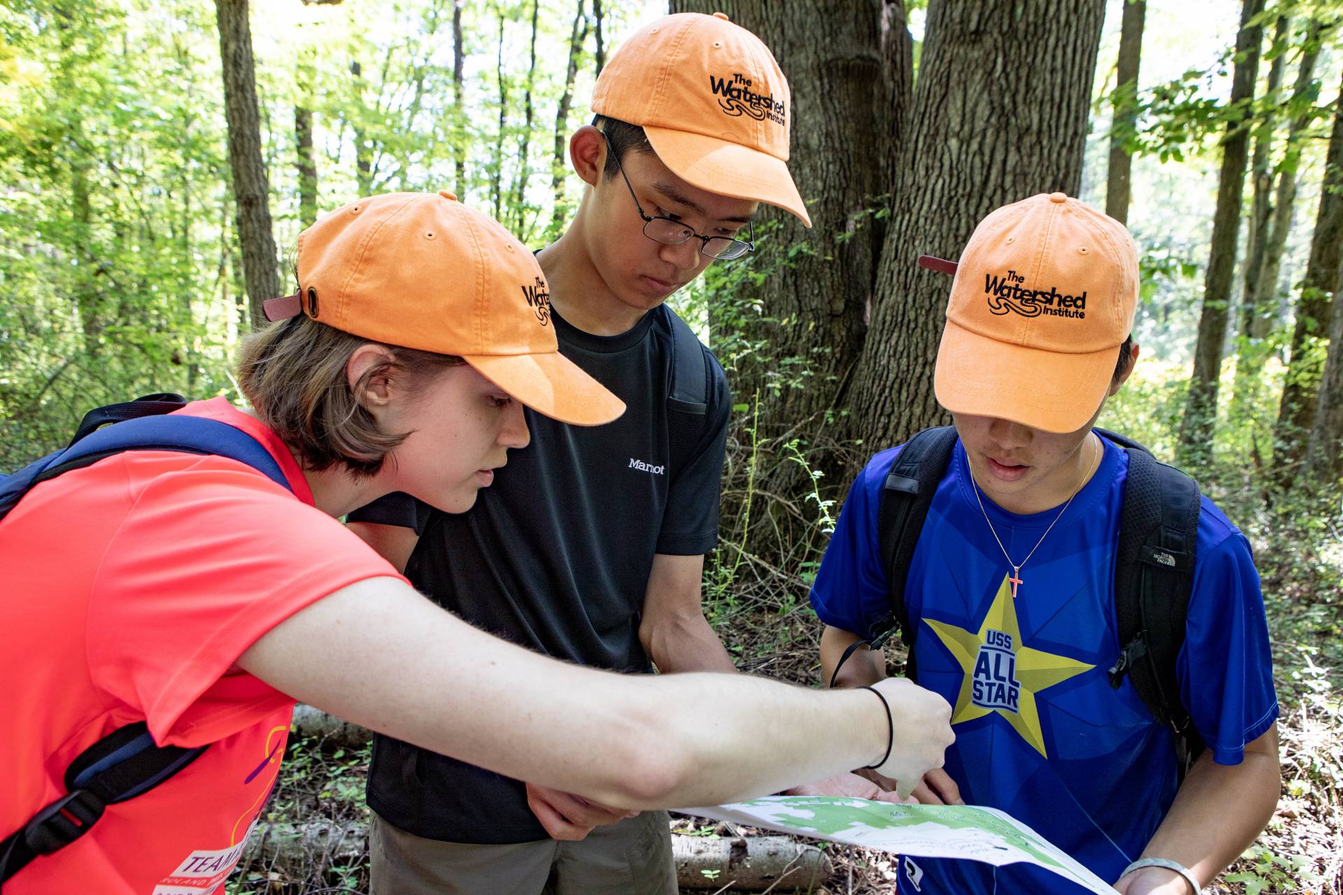 3 students look at a trail map