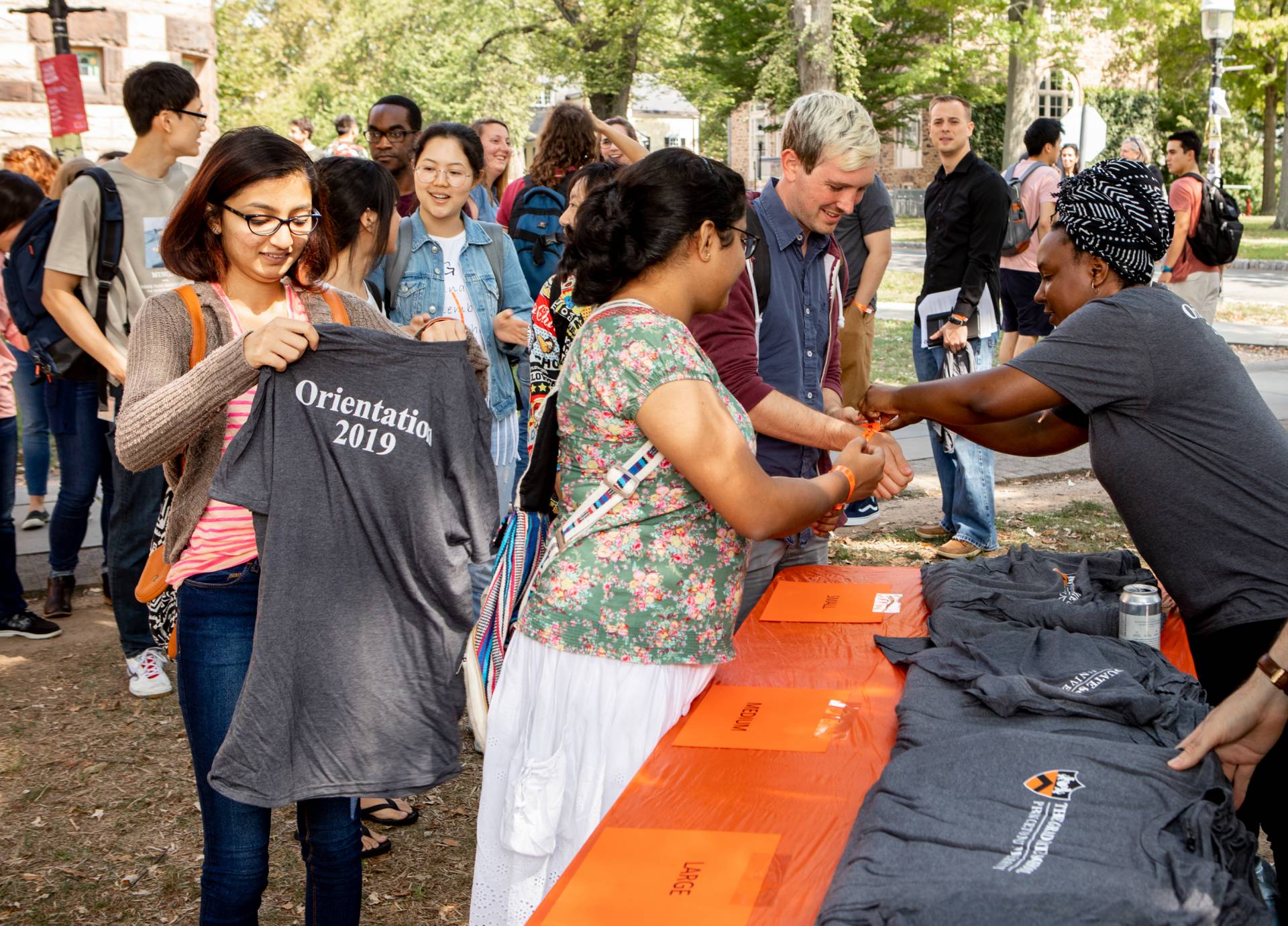Students picking up t-shirts at a table