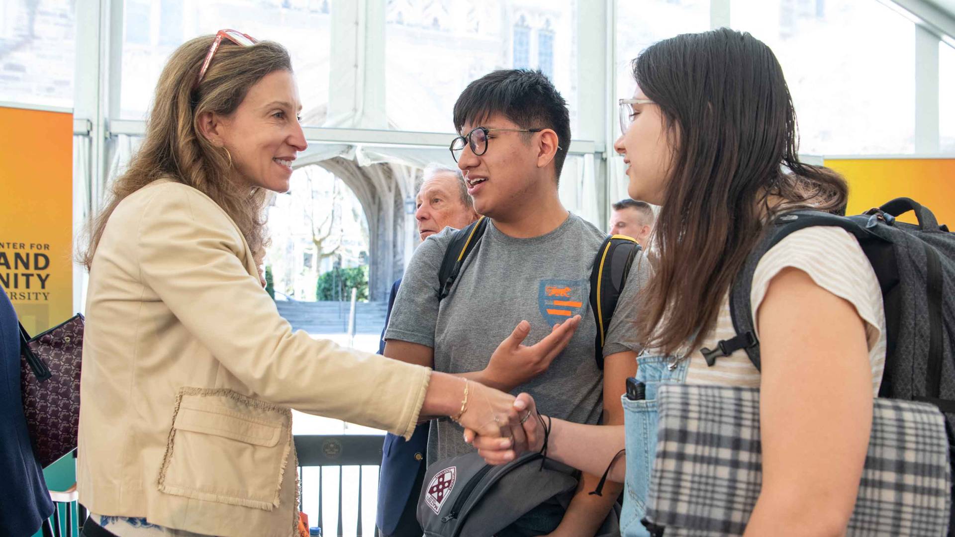 Emma Bloomberg shaking hands with students.