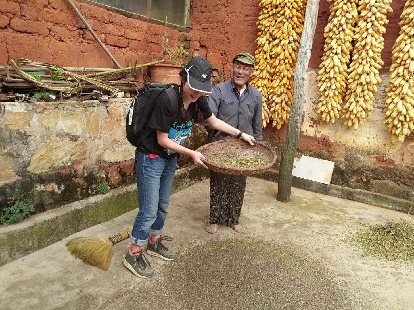 Kisara Moore sifting buckwheat in Kunming, China next to an elderly Chinese man