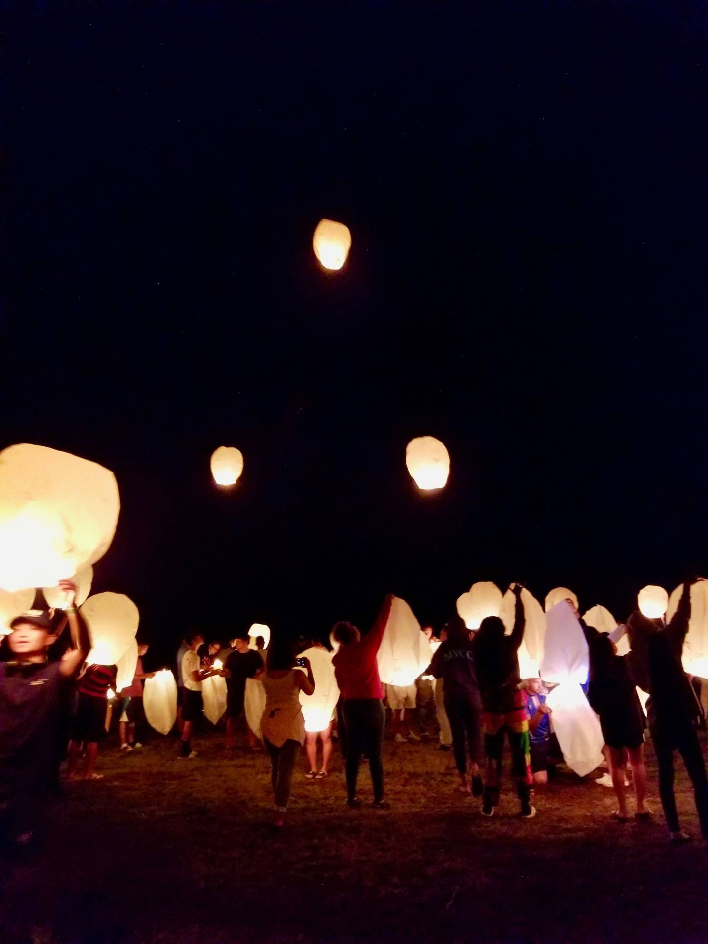 Campers releasing paper lanterns into the sky