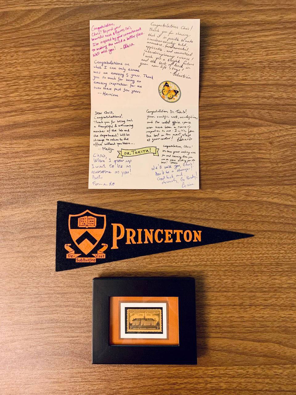 Hooding mementos: a signed card, a pennant, and stamp in a frame