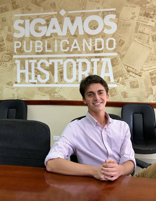 Jordan Salama in front of a wall that says "Sigamos Publicando Historia"