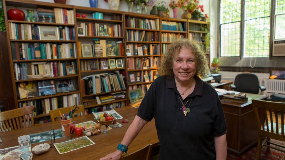 Susan Wolfson standing in her office surrounded by bookshelves