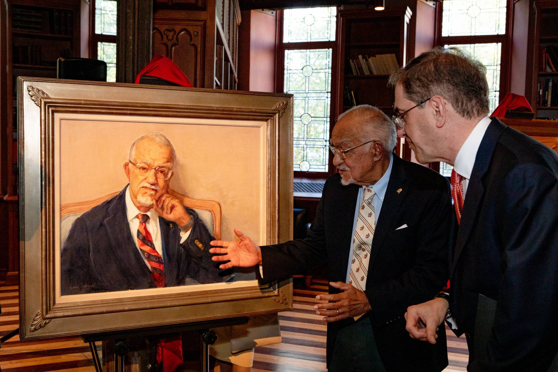 Rivers looks at his portrait with the president of the university