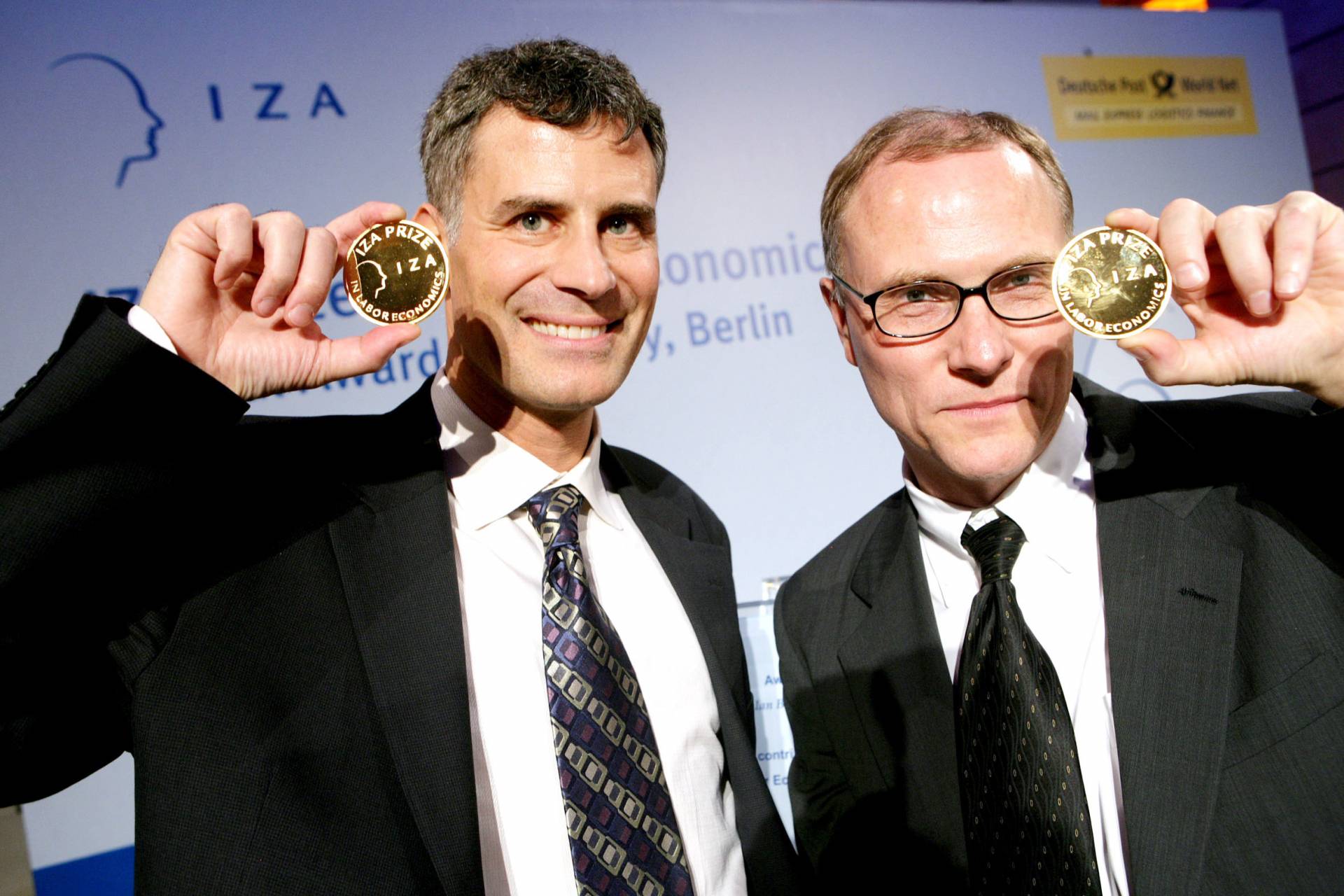 Alan Krueger and David Card hold up their IZA medals