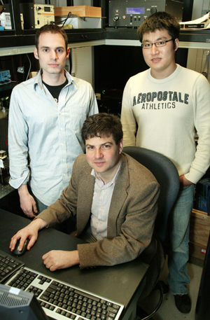 Graduate students Christopher Barsi (left) and Wenjie Wan, standing, and assistant professor Jason Fleischer, seated