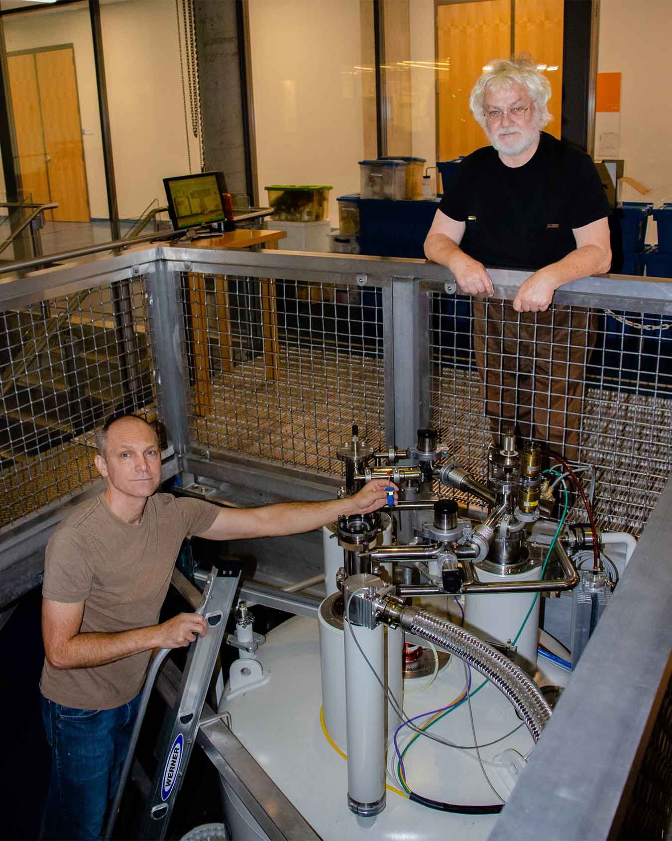 Two scientists stand over the spectroscopy tool.