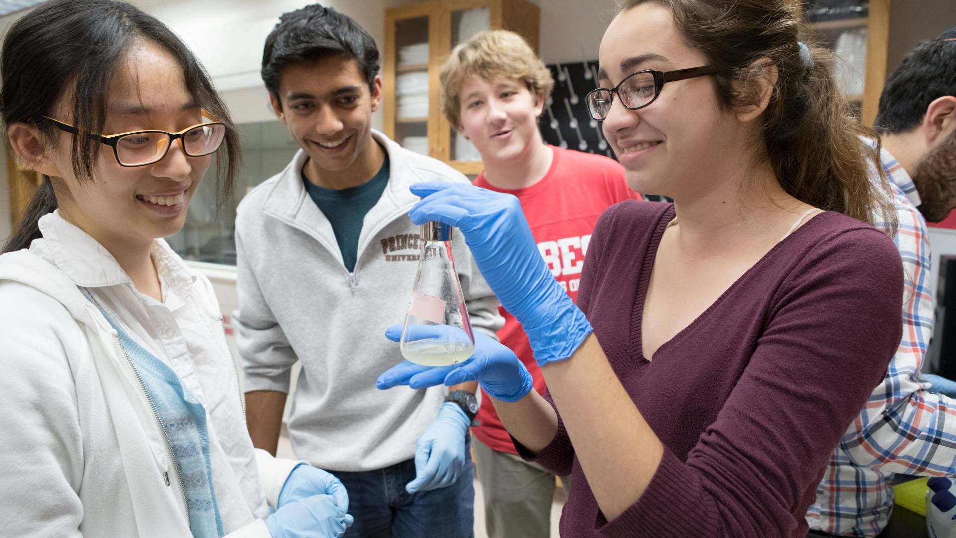 Students looking at beaker of liquid