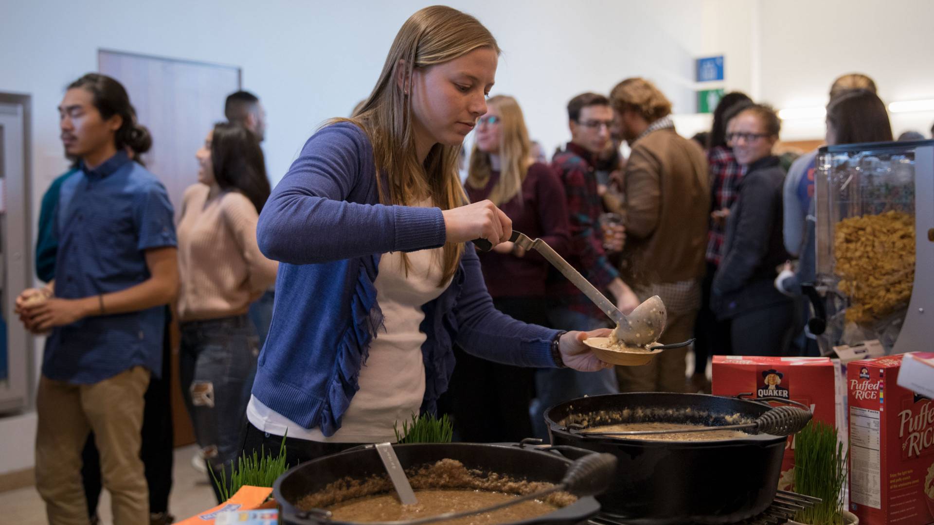 Students ladling cooked oats into bowl