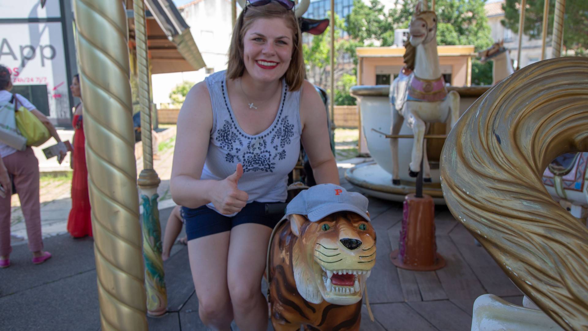 Student posing with carousel tiger wearing Princeton University hat