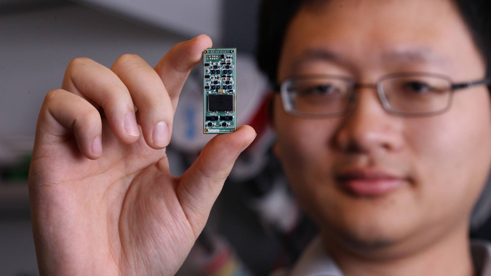 Minjie Chen holds a Power Converter chip 