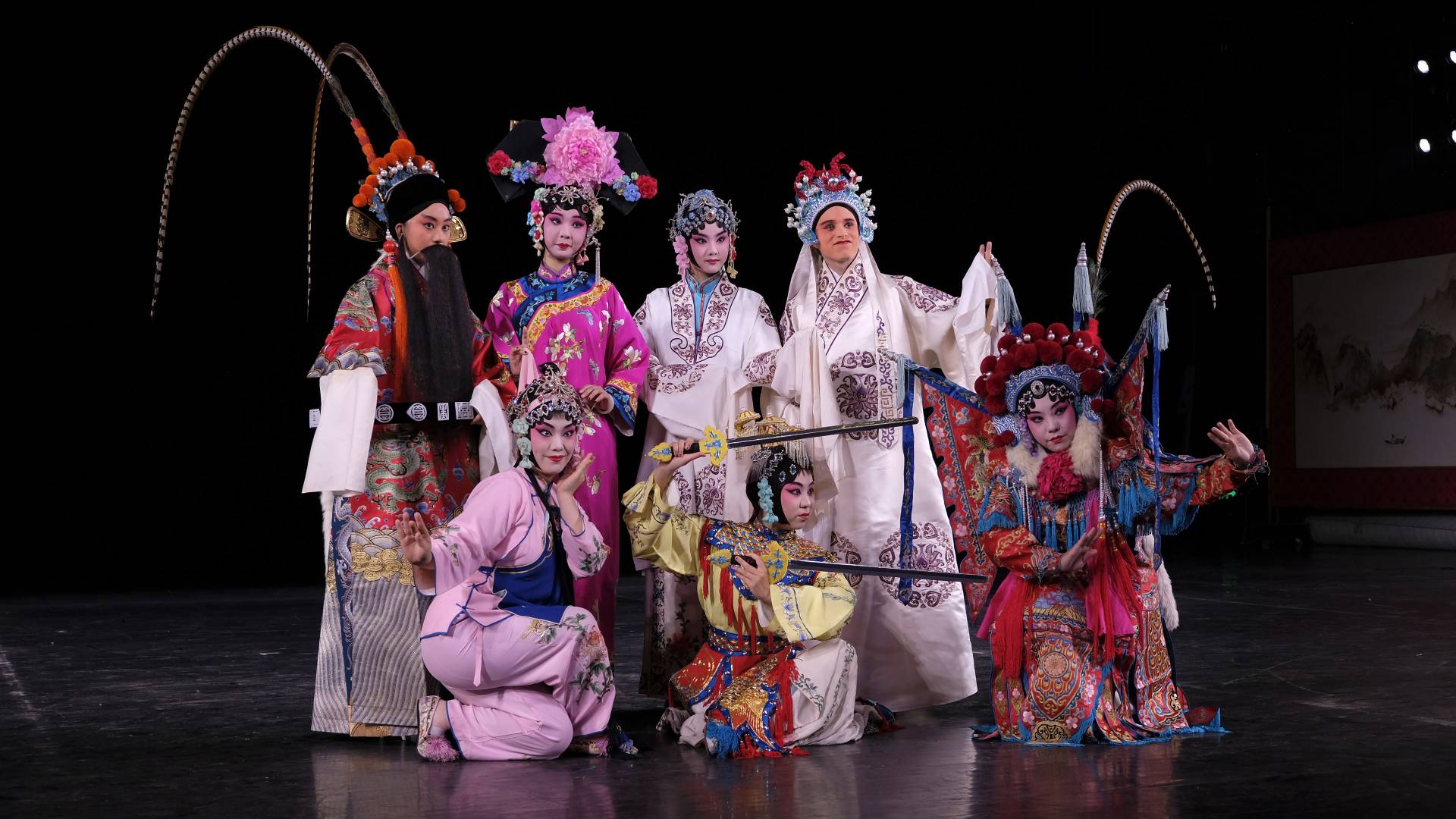 Students in Peking Opera costumes on stage