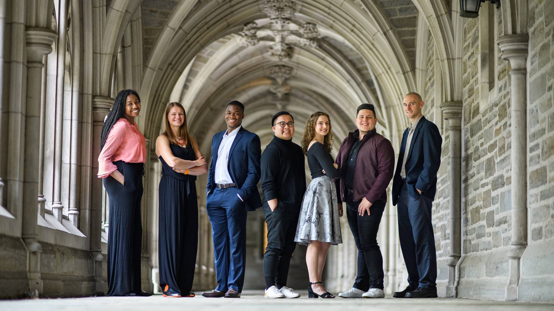Nenna Ibe, Hannah Paynter, Moyin Opeyemi, G.J. Sevillano, Marcia Brown, Samuel Vilchez Santiago and Kyle Lang standing in an iconic archway